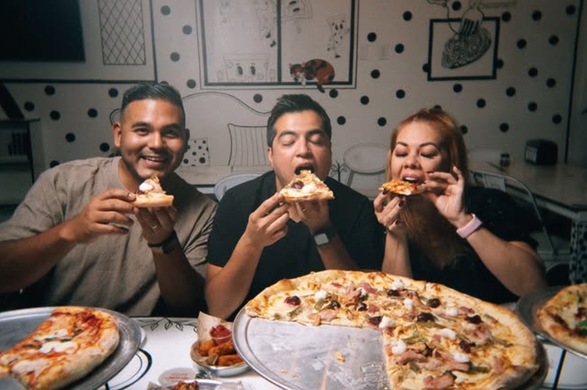 Friends sharing a 550 pizza together